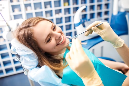 young woman smiling as she gets a filling