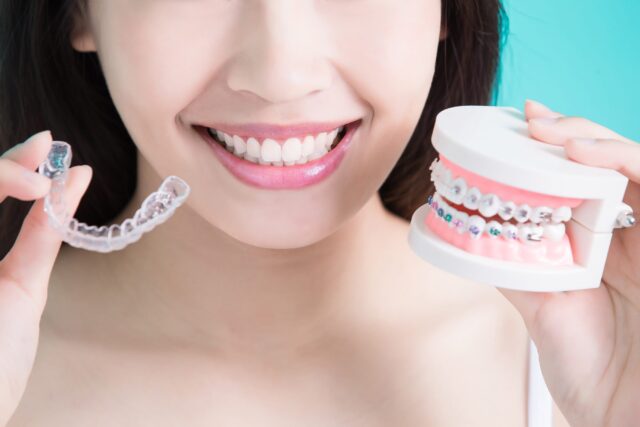 A female patient at Summit Family and Cosmetic Dentistry in Spokane, WA compares Invisalign trays with traditional metal braces.