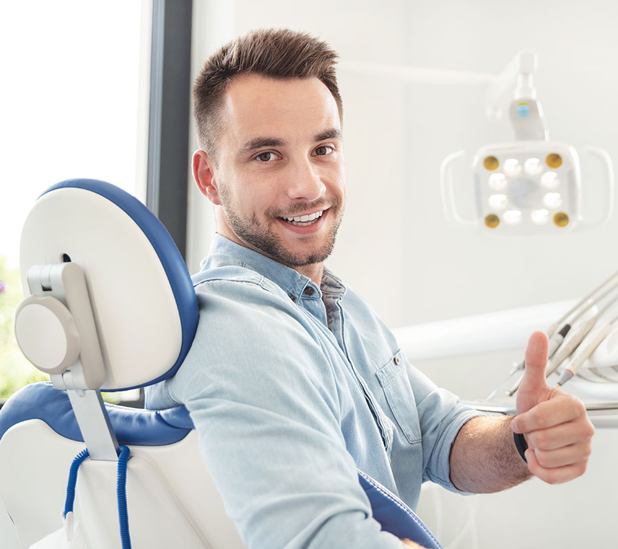 man giving a thumbs up at the dentist