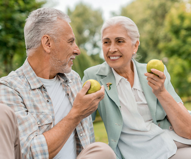 older couple eating apples after getting dental implants