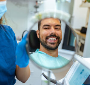 man loving his new smile at the dentist